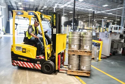 Forklift moving kegs in a warehouse